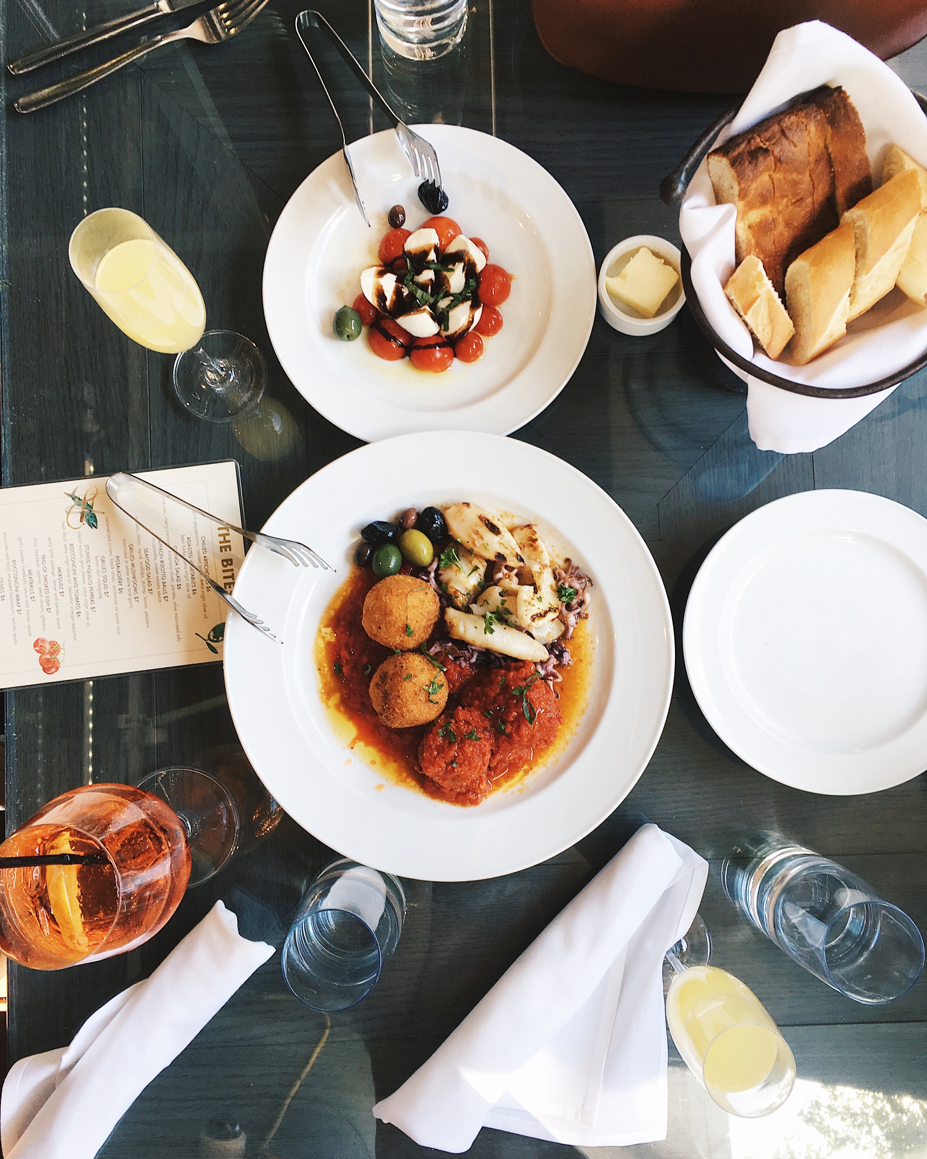 Plate of food and a glass of wine on a glass table