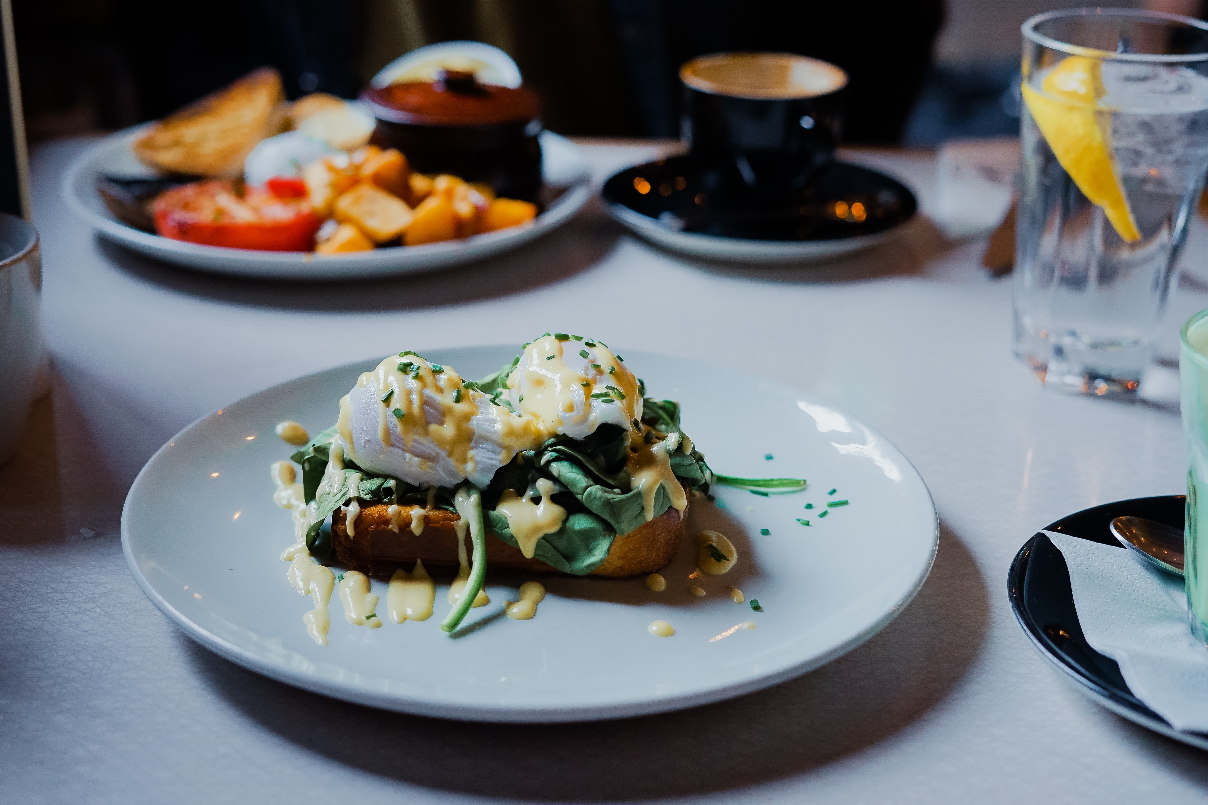 Eggs benedict on a white plate in a restaurant